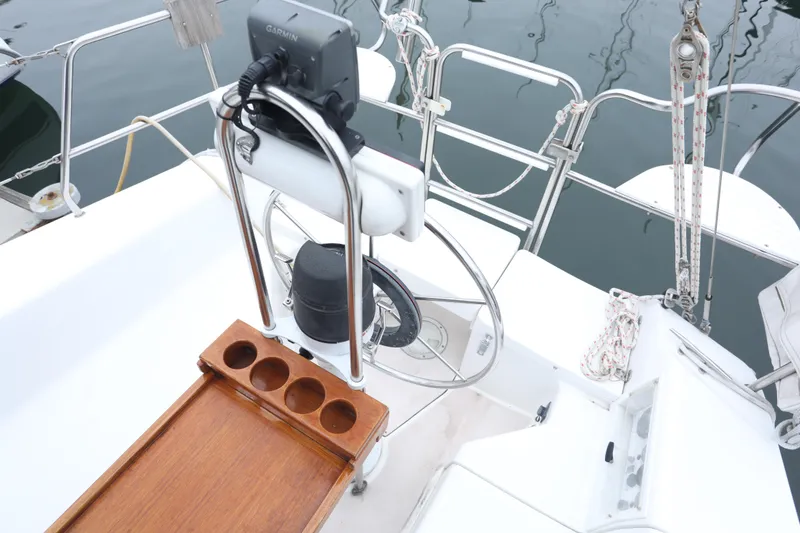 Slide: The Image of Cockpit of a 1995 Catalina 30 sailboat with steering wheel and wooden tray. - 9