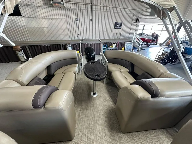 Slide: The Image of 2022 Sylvan 8522 Mirage LZ pontoon boat interior with plush seating and table. - 10