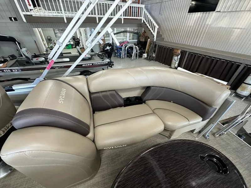 Slide: The Image of 2022 Sylvan 8522 Mirage LZ boat interior with beige and brown seating. - 12