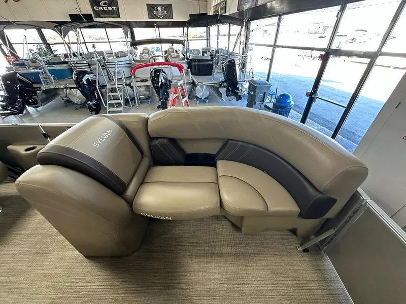 Slide: The Image of 2022 Sylvan 8522 Mirage LZ boat interior with beige seating in showroom. - 4