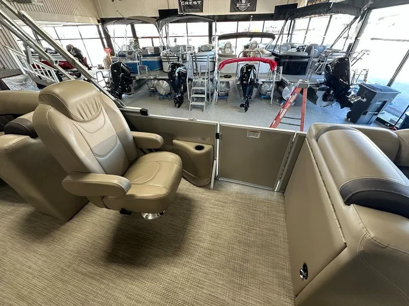 Slide: The Image of 2022 Sylvan 8522 Mirage LZ boat interior with beige seating in showroom. - 6