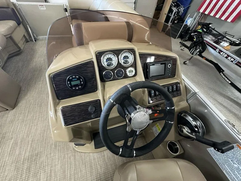 Slide: The Image of 2022 Sylvan 8522 Mirage LZ boat dashboard with steering wheel and control panel. - 8