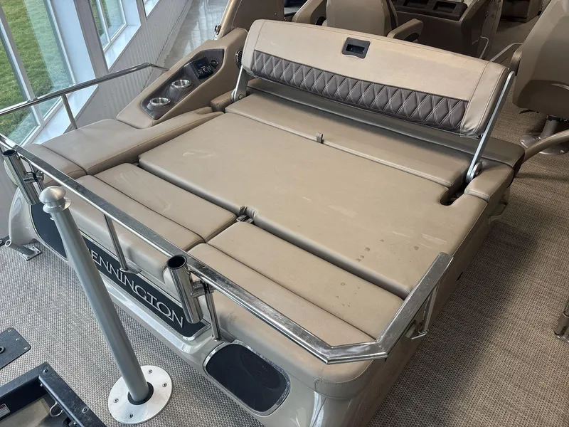 Slide: The Image of 2022 Bennington 25QXSBWA boat interior with beige seating and cup holders. - 12