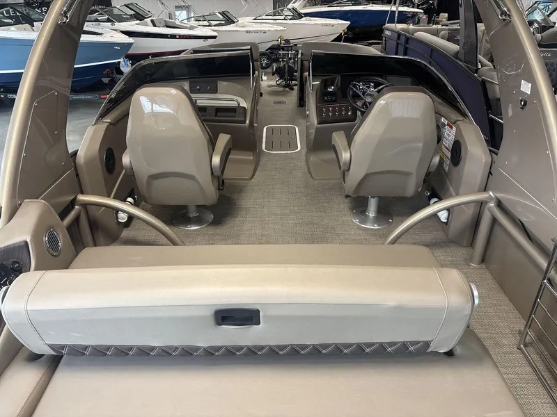 Slide: The Image of 2022 Bennington 25QXSBWA boat interior with dual captain chairs and modern dashboard. - 4