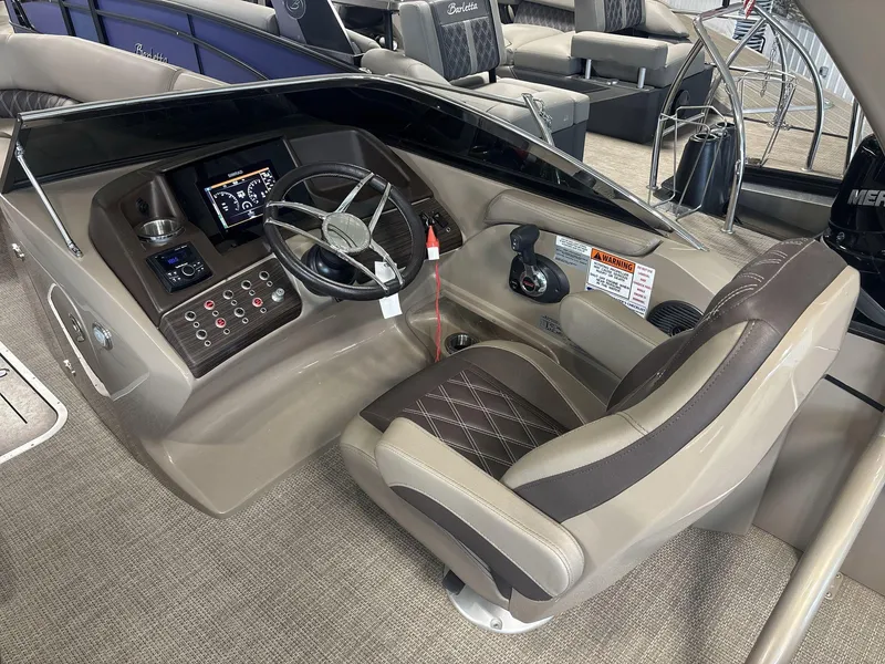 Slide: The Image of 2022 Bennington 25QXSBWA boat helm with steering wheel and control panel. - 8