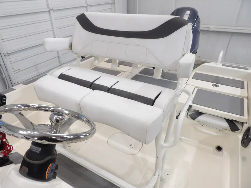 Slide: The Image of 2018 Skeeter SX2250 boat interior with white seating and steering wheel. - 15