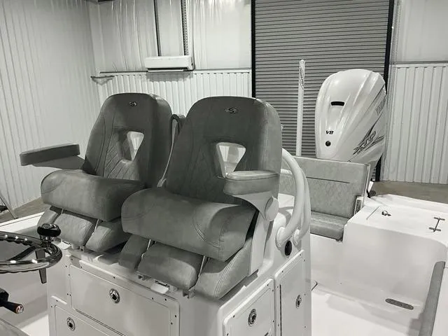 Slide: The Image of 2020 Sportsman Masters 267OE boat interior with dual gray seats and V8 engine. - 14