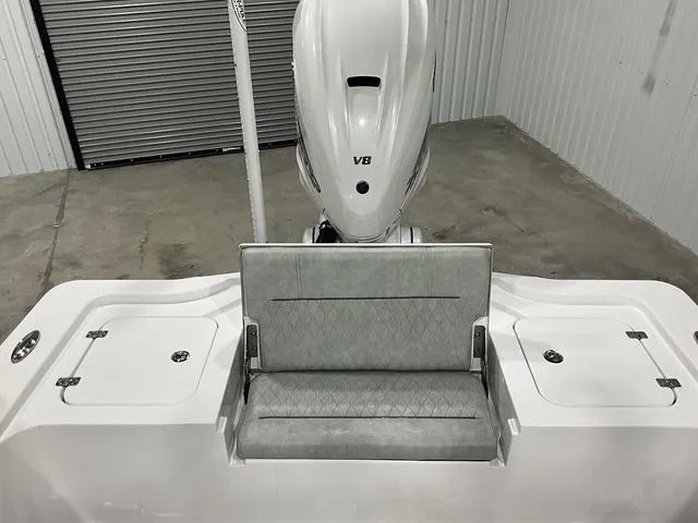 Slide: The Image of 2020 Sportsman Masters 267OE boat with cushioned seating and outboard motor in a garage. - 15