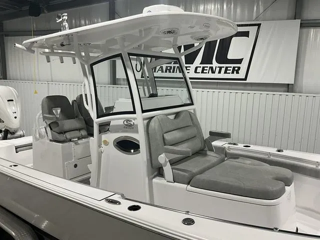 Slide: The Image of 2020 Sportsman Masters 267OE boat with cushioned seating in a marine center showroom. - 9