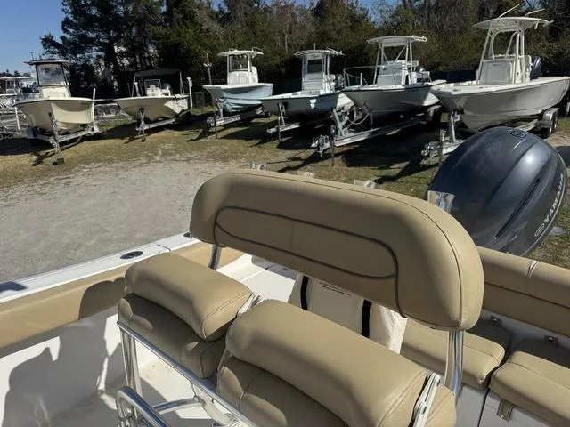 Slide: The Image of 2017 Sportsman Heritage 211 boat with tan seating, parked among other boats. - 10