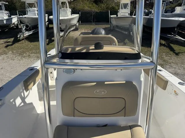 Slide: The Image of 2017 Sportsman Heritage 211 boat interior with seating and console, parked among other boats. - 8