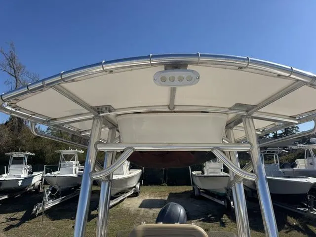 Slide: The Image of 2017 Sportsman Heritage 211 boat with T-top and LED light, parked among other boats. - 9