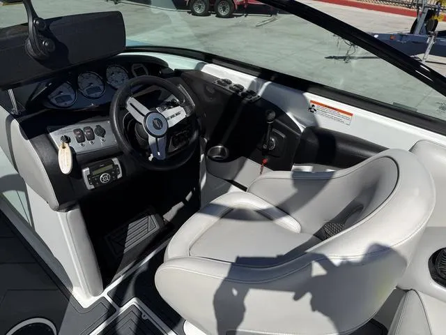Slide: The Image of 2015 Supreme S226 boat interior with steering wheel, gauges, and white captain's seat. - 10