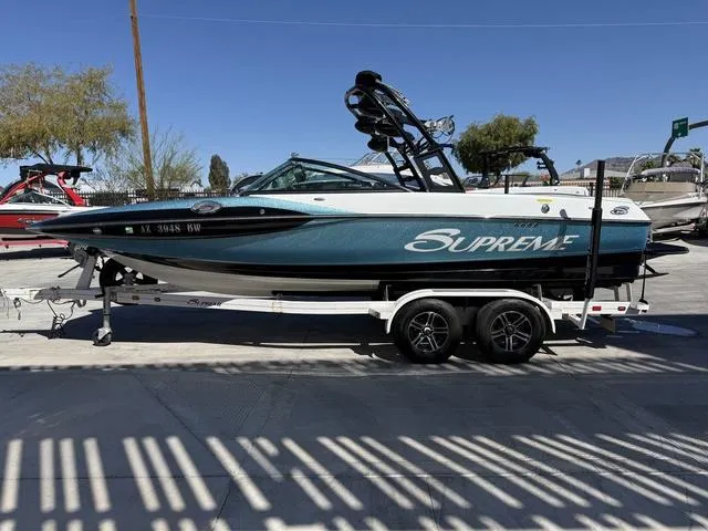 Slide: The Image of 2015 Supreme S226 boat on trailer, parked outdoors under clear blue sky. - 5