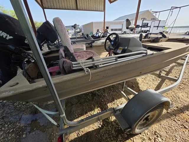 Slide: The Image of 2012 Tracker 1648 boat on trailer under shelter, with visible steering wheel and seats. - 7