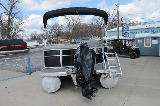 Slide: The Image of 2023 Bennington 21 SL pontoon boat with outboard motor at a marina. - 4
