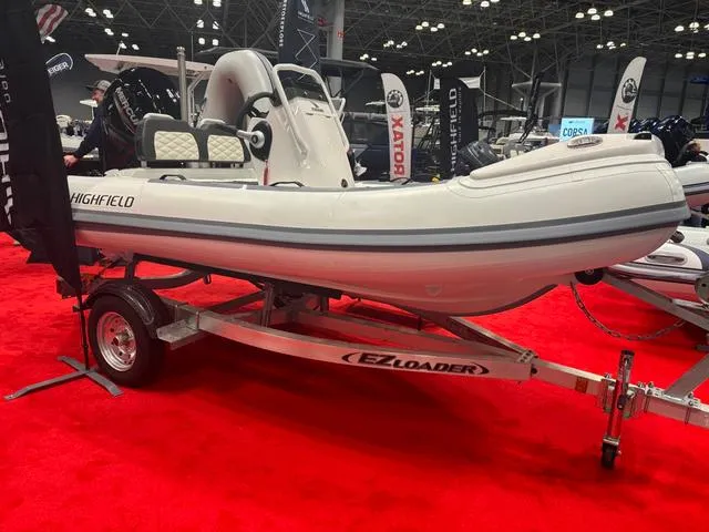 Slide: The Image of 2025 Highfield SP360 boat on EZ Loader trailer at indoor exhibition. - 1