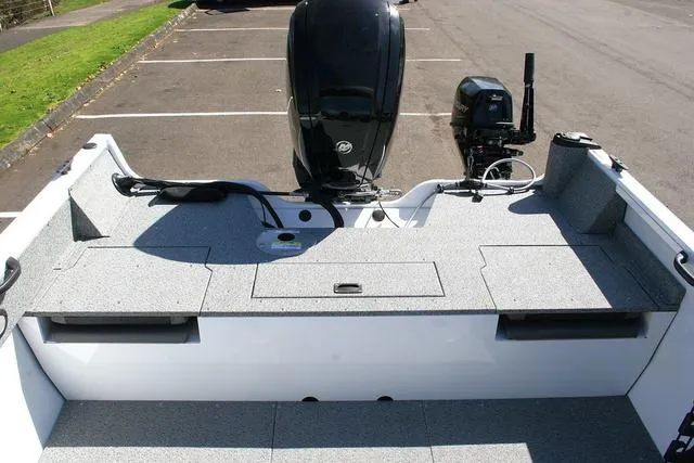 Slide: The Image of 2023 Crestliner 1700 Vision boat with outboard motor, parked on asphalt. - 11