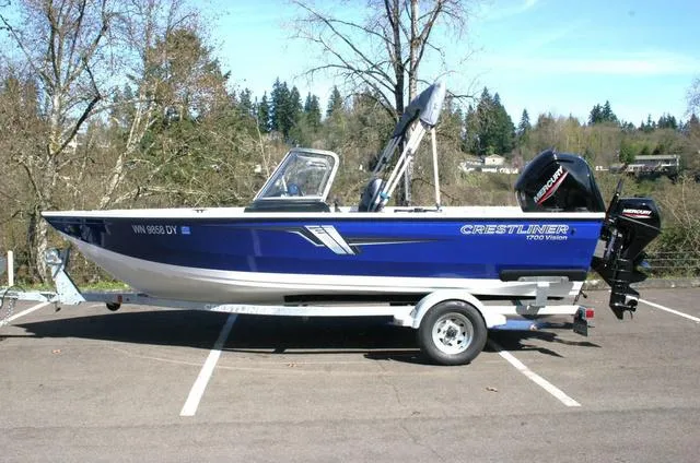 Slide: The Image of 2023 Crestliner 1700 Vision boat on trailer in parking lot, side view. - 2
