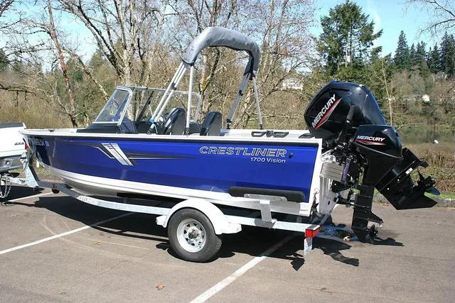Slide: The Image of 2023 Crestliner 1700 Vision boat with Mercury engine, parked outdoors. - 3