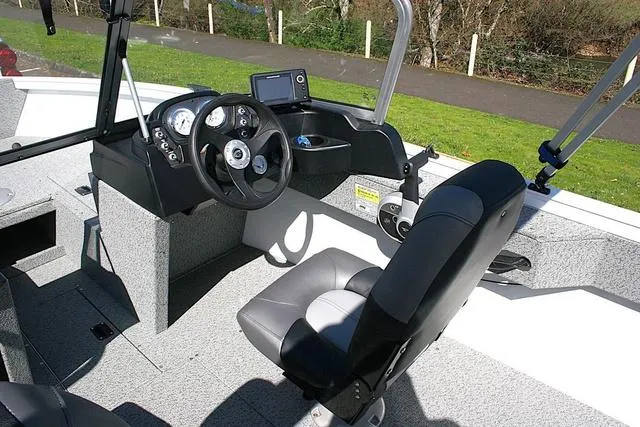 Slide: The Image of 2023 Crestliner 1700 Vision boat interior with steering console and seating. - 6