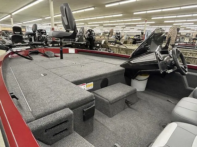 Slide: The Image of 2025 Lowe Stinger 175C boat interior with seating and steering console in showroom. - 7