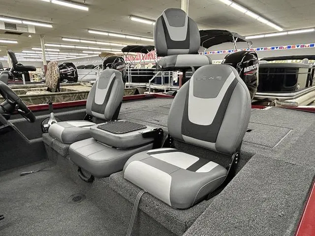 Slide: The Image of 2025 Lowe Stinger 175C boat interior with gray and black seating in showroom. - 8