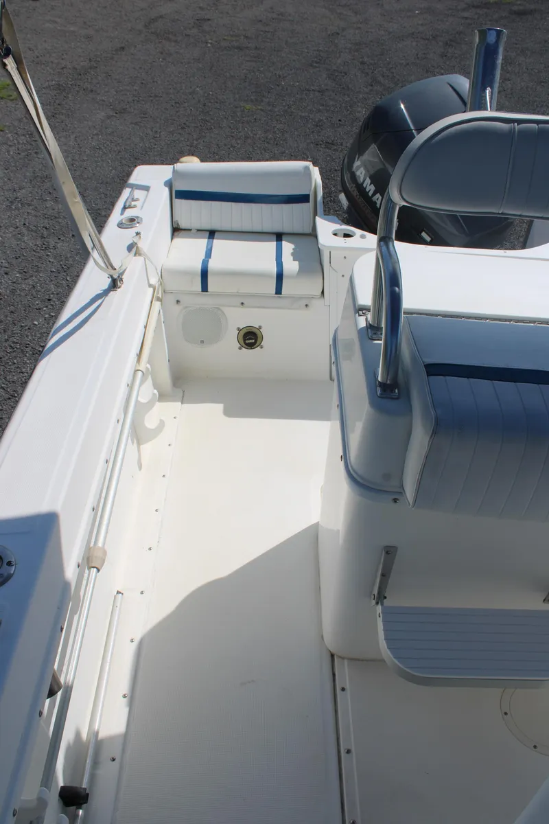Slide: The Image of 1999 Edgewater 20cc boat interior with blue and white seating, clean deck, and visible motor. - 16