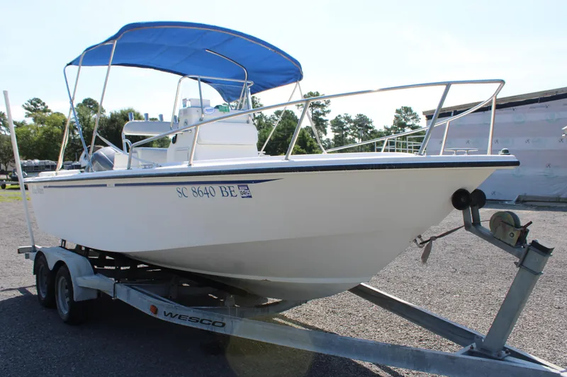 Slide: The Image of 1999 Edgewater 20cc boat on trailer with blue canopy, parked outdoors. - 4