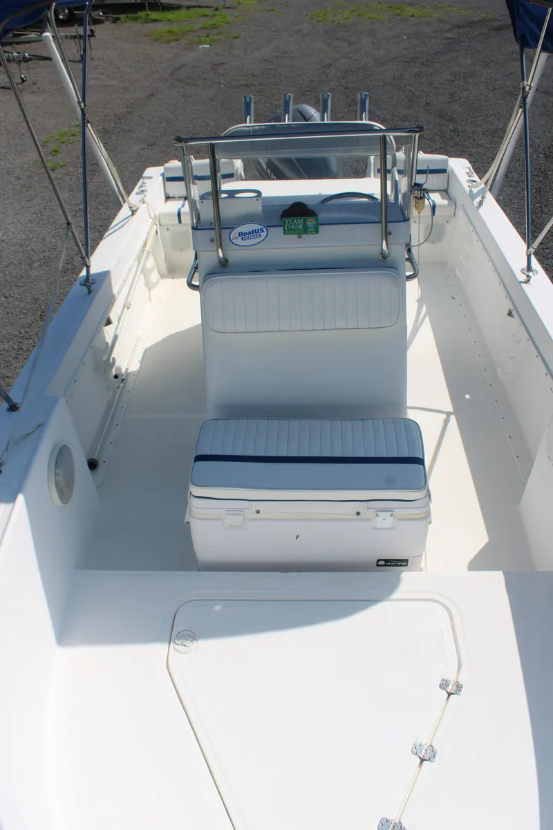 Slide: The Image of 1999 Edgewater 20cc boat interior with seating and console, featuring a clean white deck. - 7