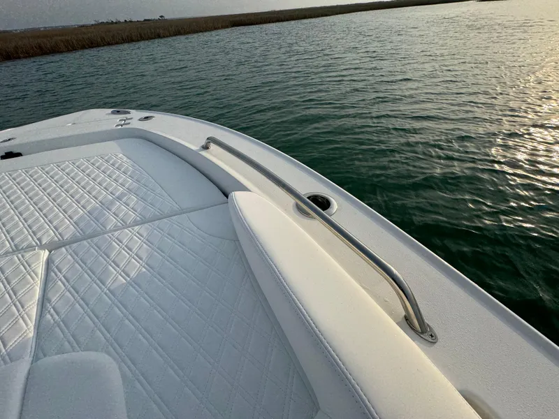 Slide: The Image of 2025 Crevalle 24 HCO boat with white seating, on calm water. - 11