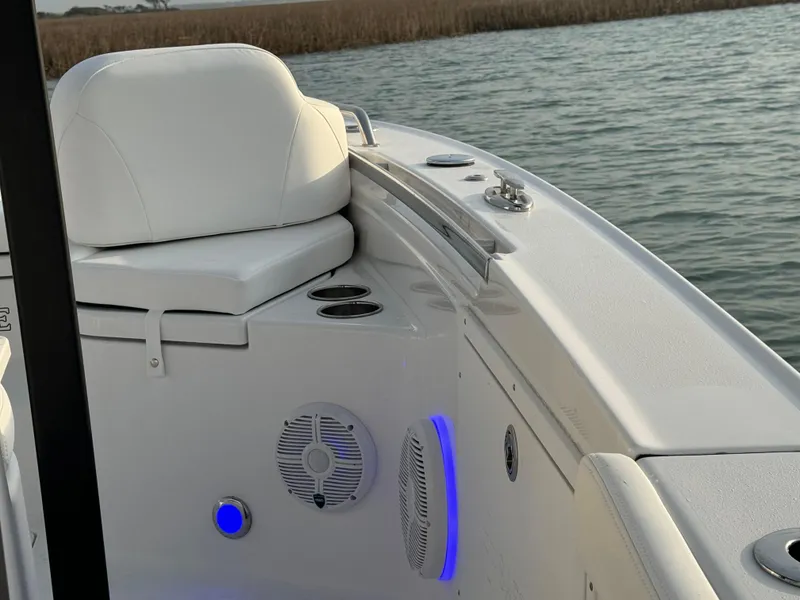 Slide: The Image of 2025 Crevalle 24 HCO boat interior with white seating and blue LED lights. - 13
