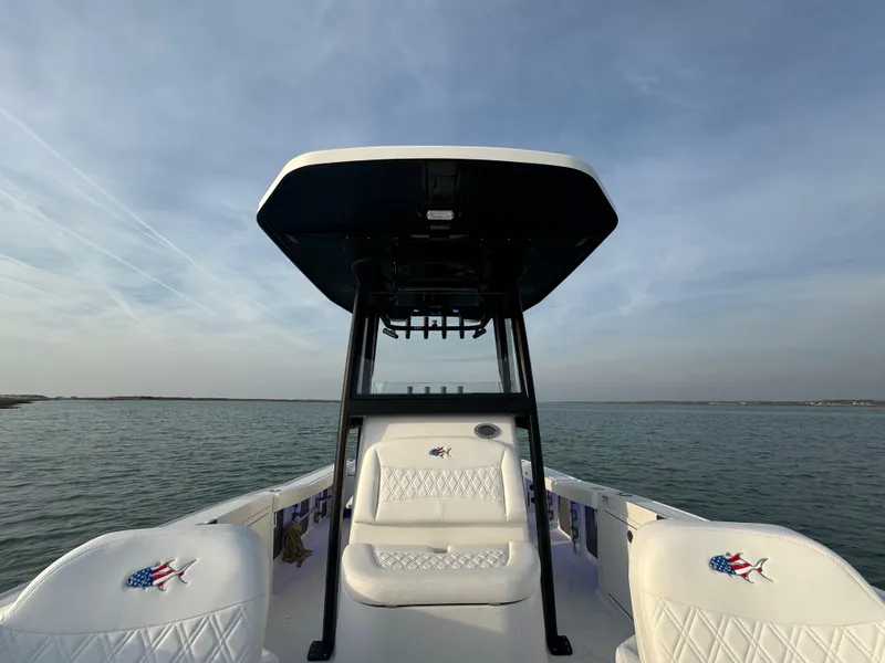 Slide: The Image of 2025 Crevalle 24 HCO boat on calm water under a clear sky. - 15