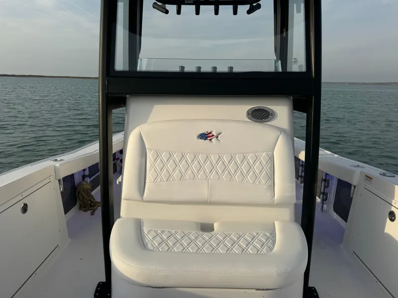 Slide: The Image of 2025 Crevalle 24 HCO boat with white seating, on calm water. - 17