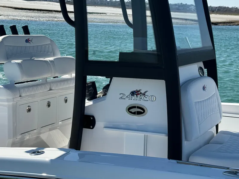 Slide: The Image of 2025 Crevalle 24 HCO boat interior with seating and console, on calm water. - 19