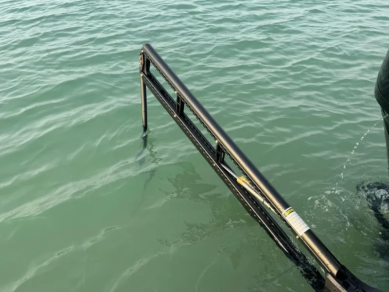 Slide: The Image of Crevalle 24 HCO 2025 boat ladder submerged in clear water. - 47