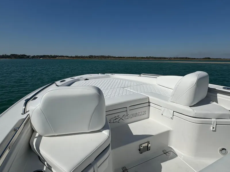 Slide: The Image of 2025 Crevalle 24 HCO boat with white seating on calm water. - 8