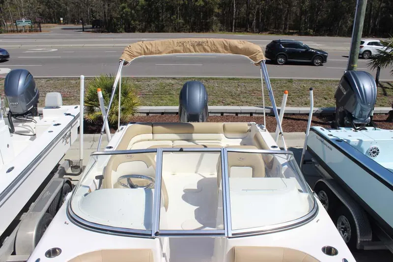Slide: The Image of 2020 Key West 203 DFS boat with beige seating and bimini top, parked near road. - 10