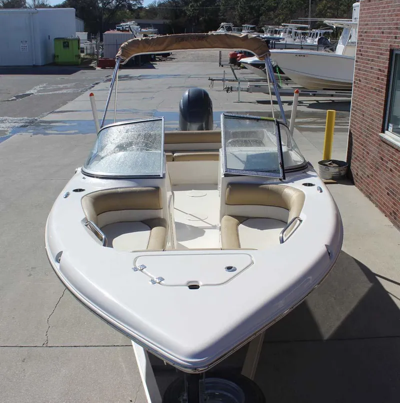 Slide: The Image of 2020 Key West 203 DFS boat with open bow seating and windshield, docked outdoors. - 2