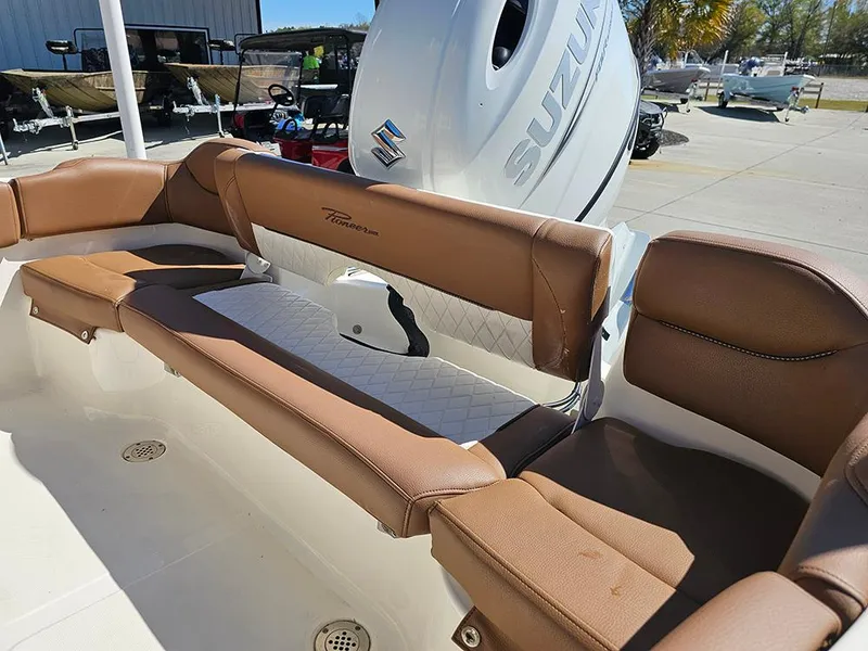 Slide: The Image of 2023 Pioneer 202 Islander boat interior with brown seating and Suzuki engine. - 10
