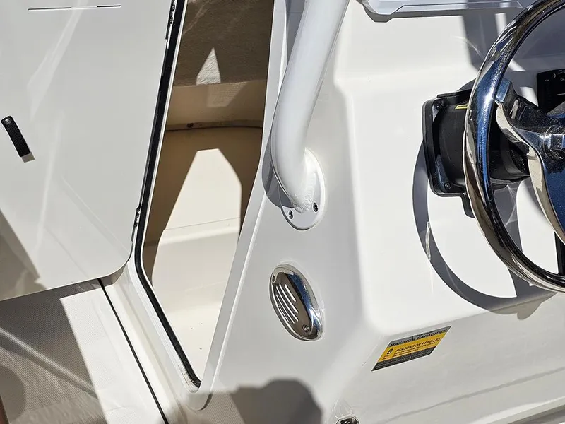 Slide: The Image of 2023 Pioneer 202 Islander boat interior with steering wheel and open compartment. - 16