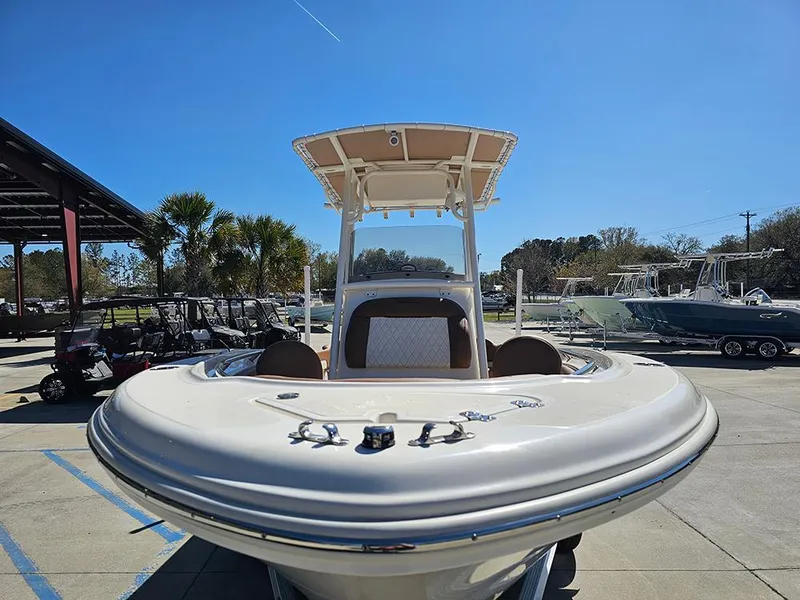 Slide: The Image of 2023 Pioneer 202 Islander boat with T-top, parked outdoors under clear blue sky. - 4