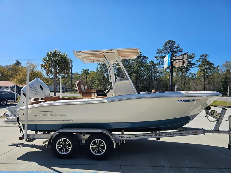 Slide: The Image of 2023 Pioneer 202 Islander boat on trailer, parked outdoors under clear blue sky. - 6