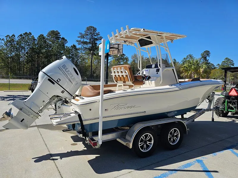 Slide: The Image of 2023 Pioneer 202 Islander boat on trailer with outboard motor, parked outdoors. - 7