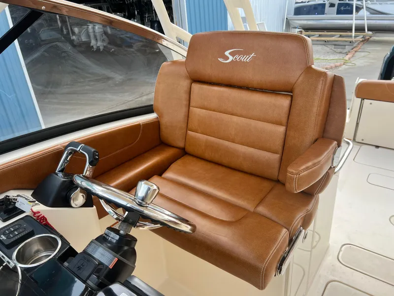 Slide: The Image of 2018 Scout 255 Dorado boat helm with brown leather seat and steering wheel. - 12