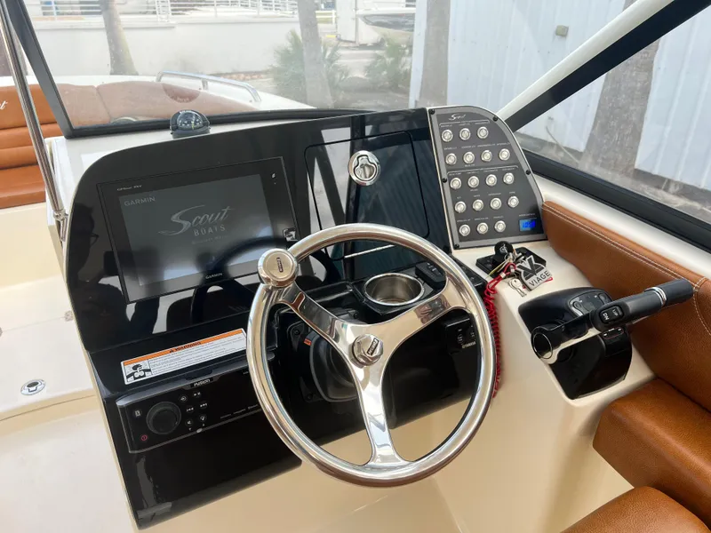 Slide: The Image of 2018 Scout 255 Dorado boat dashboard with steering wheel and control panel. - 13