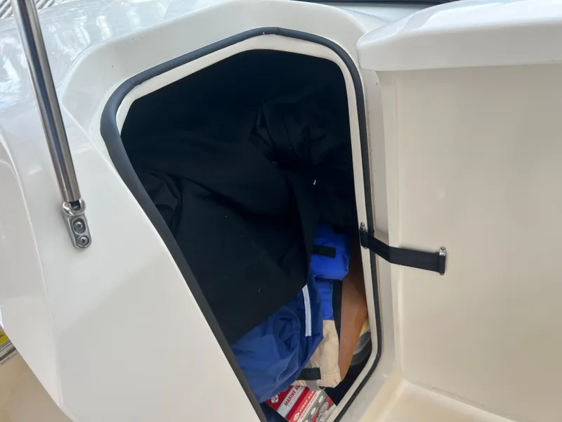 Slide: The Image of Storage compartment on a 2018 Scout 255 Dorado boat, containing various items. - 18