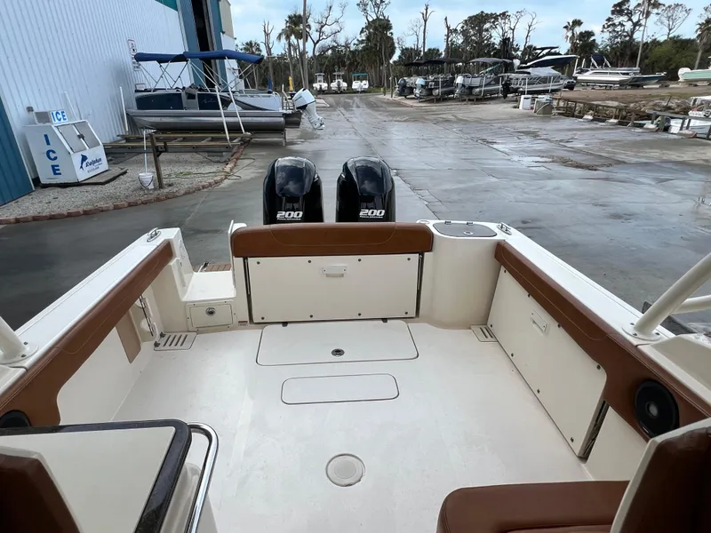 Slide: The Image of 2018 Scout 255 Dorado boat with dual engines, docked at a marina. - 7