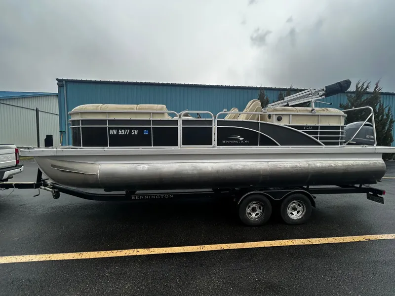 Slide: The Image of 2015 Bennington 2250 GSR pontoon boat on trailer, parked outdoors. - 1