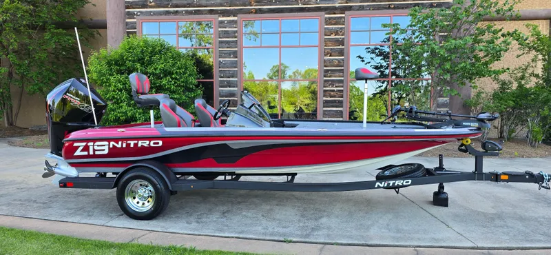 Slide: The Image of 2025 Nitro Z19 boat with red and black design, parked on a trailer. - 2